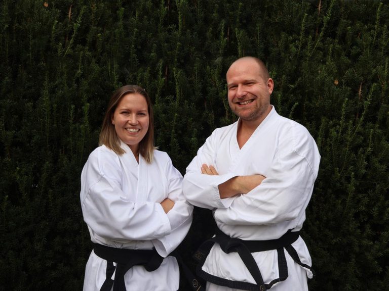 Zwei Taekwondo-Kämpfer lächelnd in weißem Dobok und schwarzer Gürtel